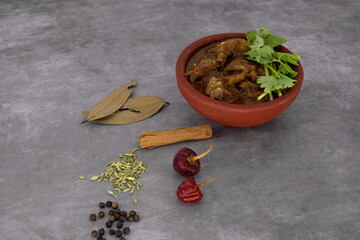 Indian cuisine, Spicy and delicious mutton curry in traditional clay pot. Tasty mutton roast with Indian spices .Mutton masala -Selective focus photograph.