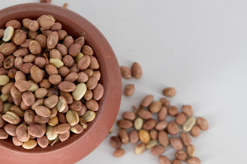 Selective focused Indian health snack called Varuth kadalai , rosted peanuts with salt on an isolated white background. Roasted without oil and very healthy daily snack