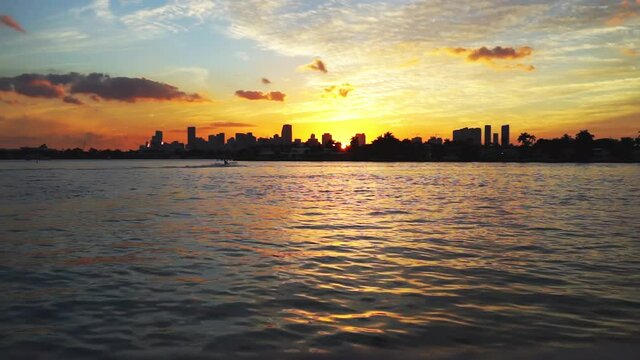 Downtown Miami cityscape skyline during evening sunset in Florida with Intracoastal water and financial buildings with boat jet ski