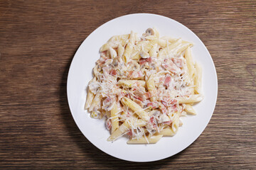 plate of pasta with ham and mushrooms, top view