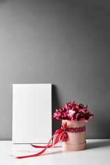 Blank canvas mockup with dried flowers on gray wall