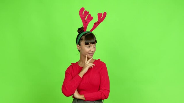Young woman wearing christmas hat standing and thinking an idea pointing the finger up over isolated background. Green screen chroma key