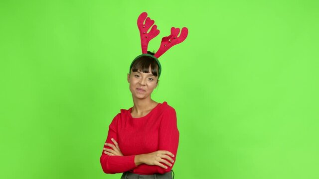 Young woman wearing christmas hat smiling and looking to the front with confident face over isolated background. Green screen chroma key