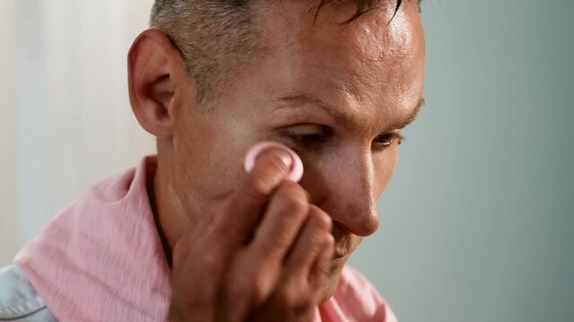 Close Up portrait of Man putting makeup on his face