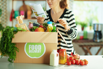 Closeup on happy woman with food box in kitchen