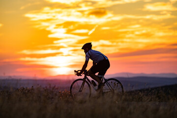Fototapeta na wymiar cyclist silhouette at sunset sports and fitness concept
