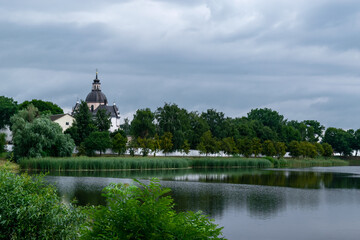 Fototapeta na wymiar Lake overlooking the old Farny Church in Nesvizh, Belarus. Beautiful summer landscape with architectural elements.