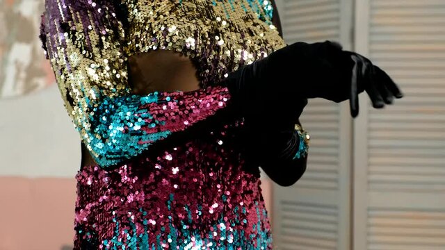 CU shot of Male in glitter dress is putting on gloves. Makeup Male in evening gown. 4k LGBT concept