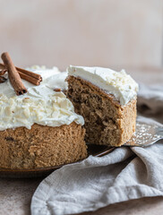 Homemade sponge cake or biscuit with nuts and spices decorated with butter cream or cream cheese icing.