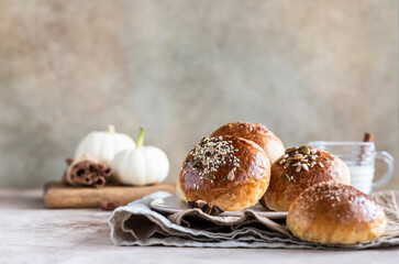 Sweet pumpkin buns with cinnamon and anise, light concrete background.