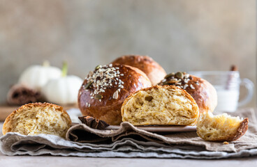Sweet pumpkin buns with cinnamon and anise, light concrete background.