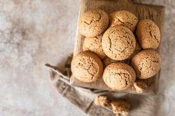 Oatmeal cookies on wooden cutting board, brown concrete background. Healthy snack or dessert. Top view.