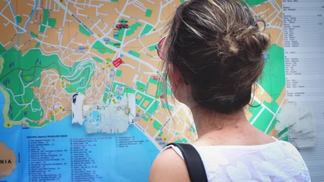 Ohrid, Macedonia - 12 Jun, 2021: Beautiful tourist woman checking a city map
