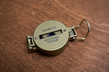 A compass with a closed protective cover lies on the table