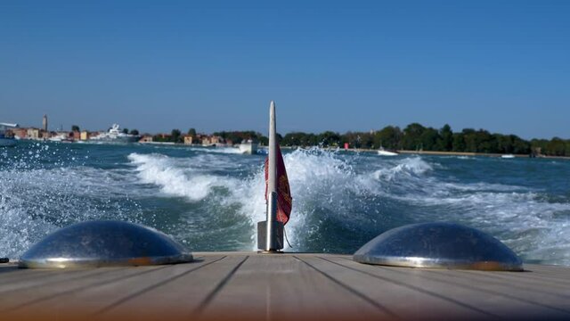 The slipstream at the back of a wooden boat in Venice on a sunny day