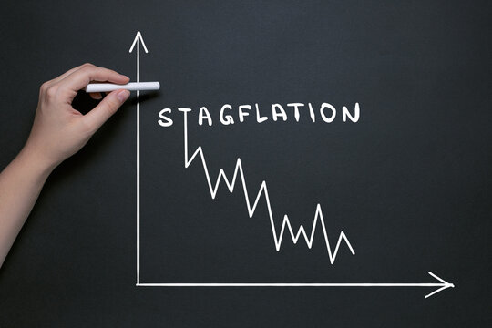 stagflation garfik, hand draws on the blackboard with chalk, the word stagflation, market fall and inflationary risks with the concept of a stifling economy