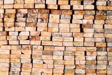 Background from wooden boards close-up. The surface of the end of the board. Stacked timber, lumber, woodworking