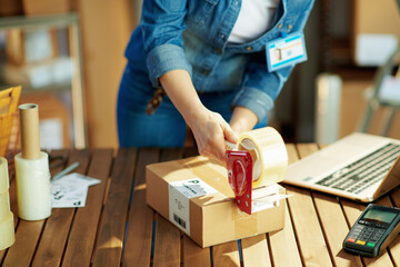 Closeup on female in jeans with parcels in warehouse