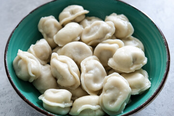 Tasty meat dumplings in green plate on a table, russian pelmeni