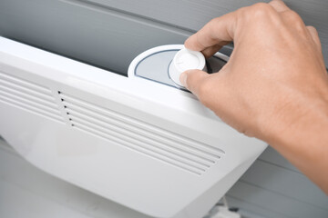 Hand regulating, setting temperature on a convector, heater thermostate in the room