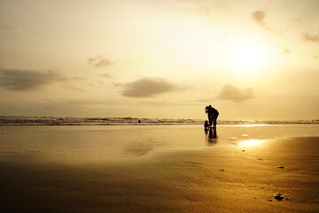 Obraz premium silhouette of people under the moment of sunset on parangtritis beach, Yogyakarta