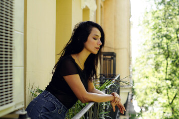 Closeup shot of a Hispanic female looking down from her balcony