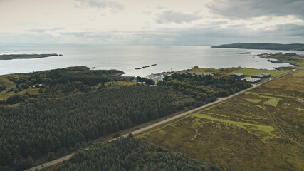 Whiskey distillery warehouse at sea bay. Green forest at seascape. Nobody nature landscape. Rural...