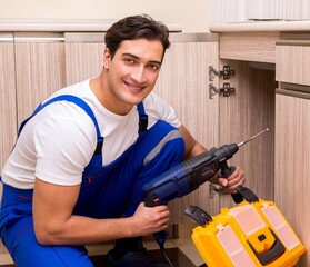 Young repairman working at the kitchen