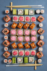 Traditional Japanese food - sushi, rolls and sauce on a dark background. Top view