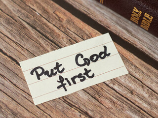 Put God Jesus Christ first. A handwritten quote from Scripture with closed Holy Bible Book. The...