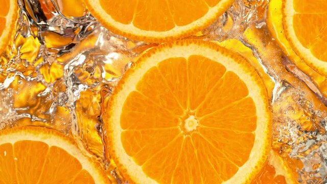 Super Slow Motion Shot of Splashing Fresh Orange Slices into Water at 1000 fps.