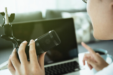 Unrecognizable Asian young man making a home podcast.