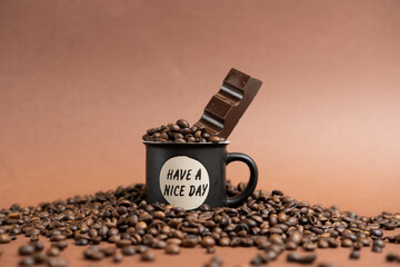 Obraz premium Tazzina del caffè Nera con chicchi e Cioccolato su sfondo Marrone Chiaro
