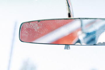 A horizontal image of an isolated retro vintage rearview mirror in a vehicle.