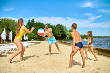 A family playing beach volleyball and feeling happy