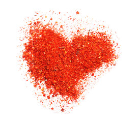 Heart shape made of red chili powder on white background