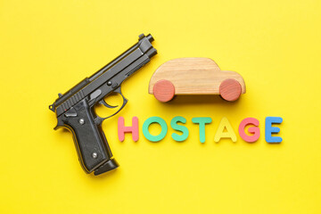 Car with gun and word HOSTAGE on color background