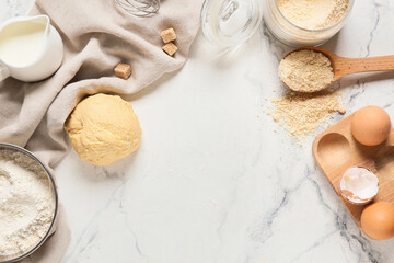 Fresh raw dough and ingredients on light background