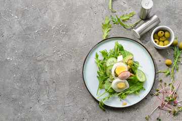 Plate with healthy salad with egg on grey background