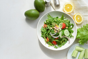 Plate with healthy salad on light background