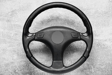 Black steering wheel on grey background