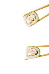 Chopsticks taking delicious sushi rolls with avocado on white background