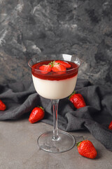 Delicious homemade panna cotta with strawberry in glass on grunge background