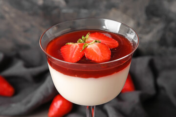 Delicious panna cotta with strawberry in glass on table, closeup