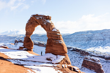 Man standing beneath Delicate Arch