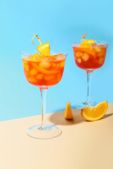 Glasses of Aperol spritz cocktail on color background