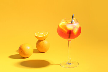 Glass of Aperol spritz cocktail on color background