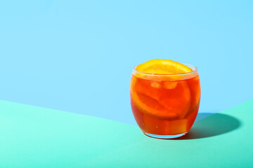 Glass of Aperol spritz cocktail on color background