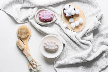 Bowls with massage soap bars and bath supplies on light background