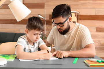 Little boy with his father doing lessons at home